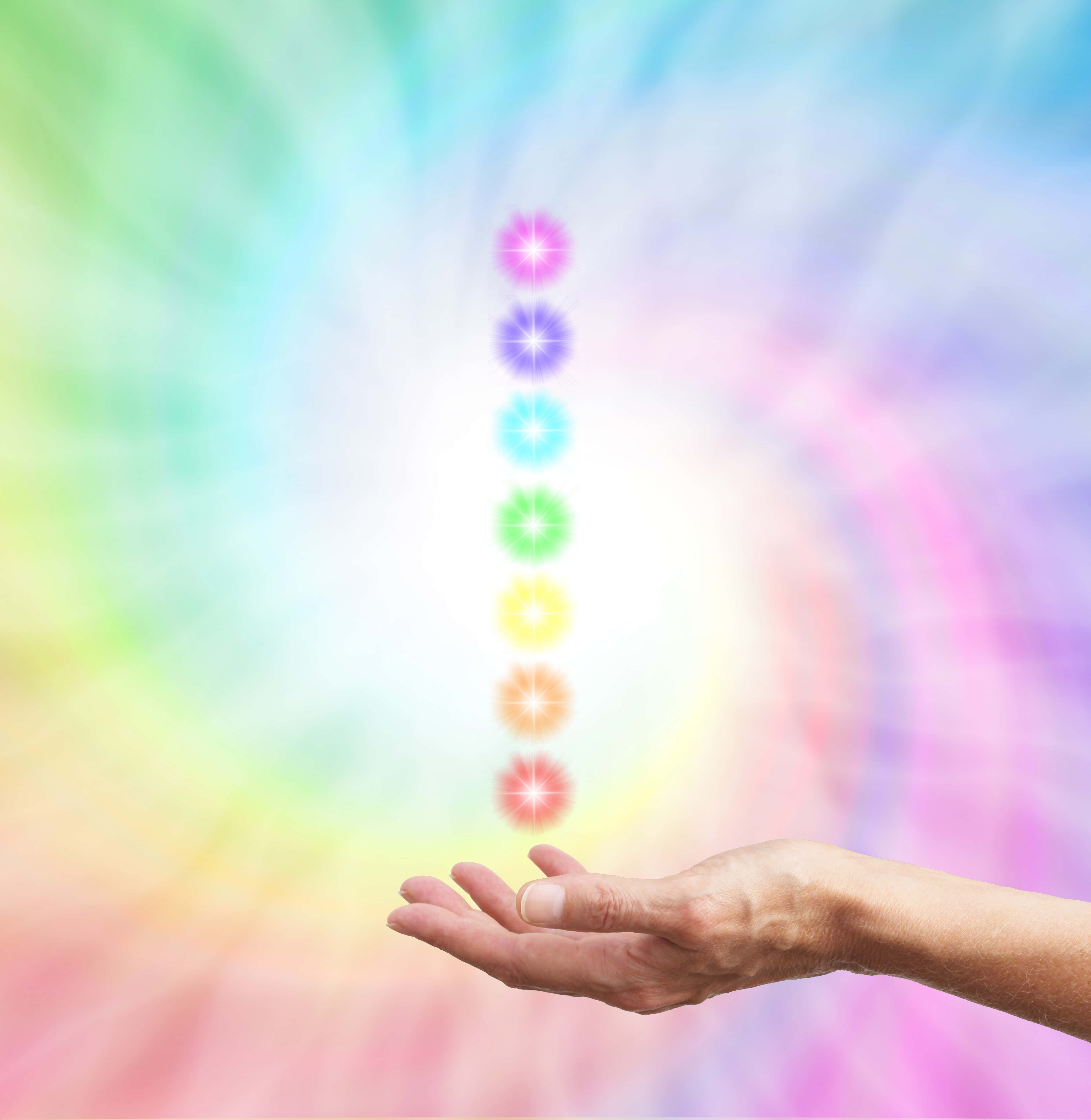 A rainbow of colors and the chakra icons with a hand reaching out.
